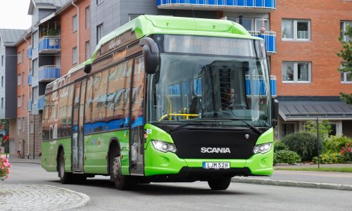 A green Scania Citywide LE  fuel public transportation bus in the city center operated on CNG fuel.